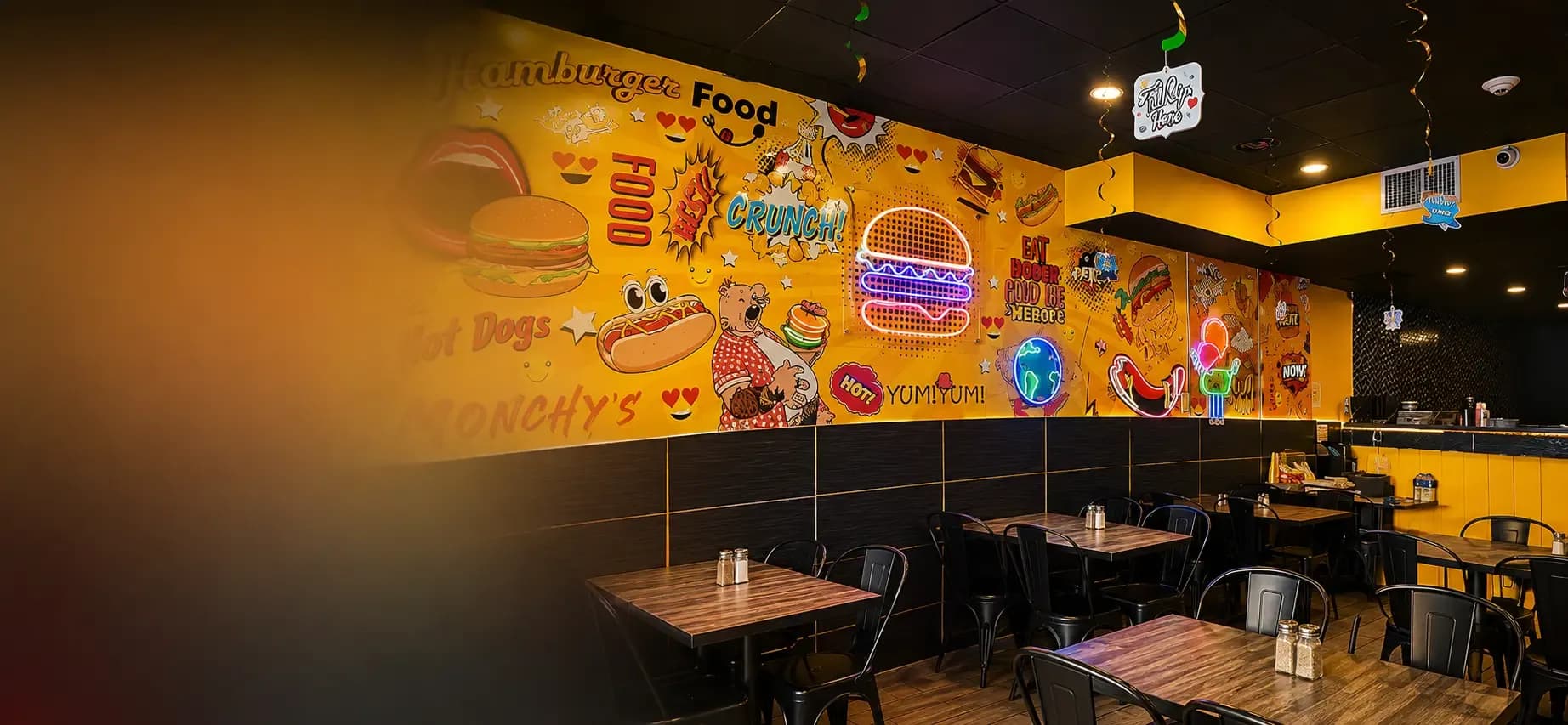 Colorful interior of Monchy's, a Colombian fast food restaurant in New Jersey, with a mural and tables